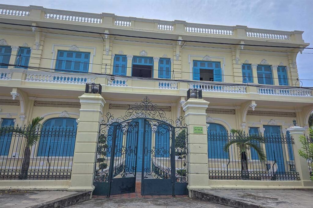 The yellow facade and blue window shutters of Cong Tu Bac Lieu House