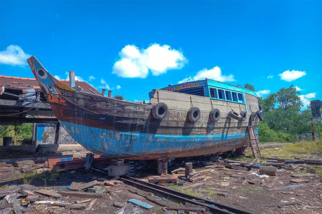 Wooden riverboat under repair at a small dockyard on Dragon Island (Tân Long), Mekong Delta.