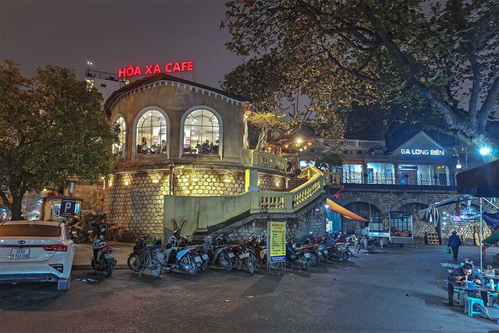 Nighttime view of Hoa Xa Café and Long Bien Train Station next to each other