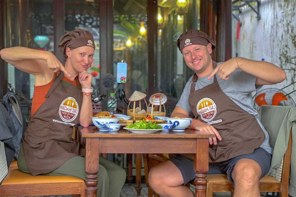 Two tourists in aprons doing a Hue cooking class 
