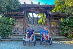 Two tourists both on their on cyclo with local rider doing a Hue food tour by cyclo
