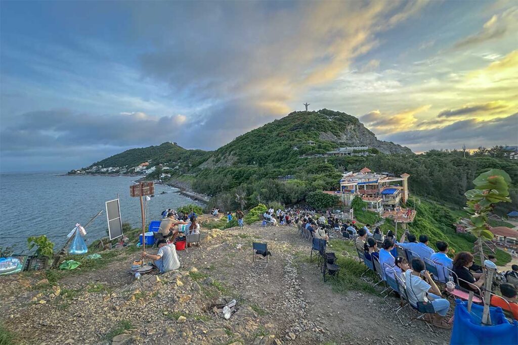 Nghinh Phong Cape full of chairs of local vendors with people watching the sunset