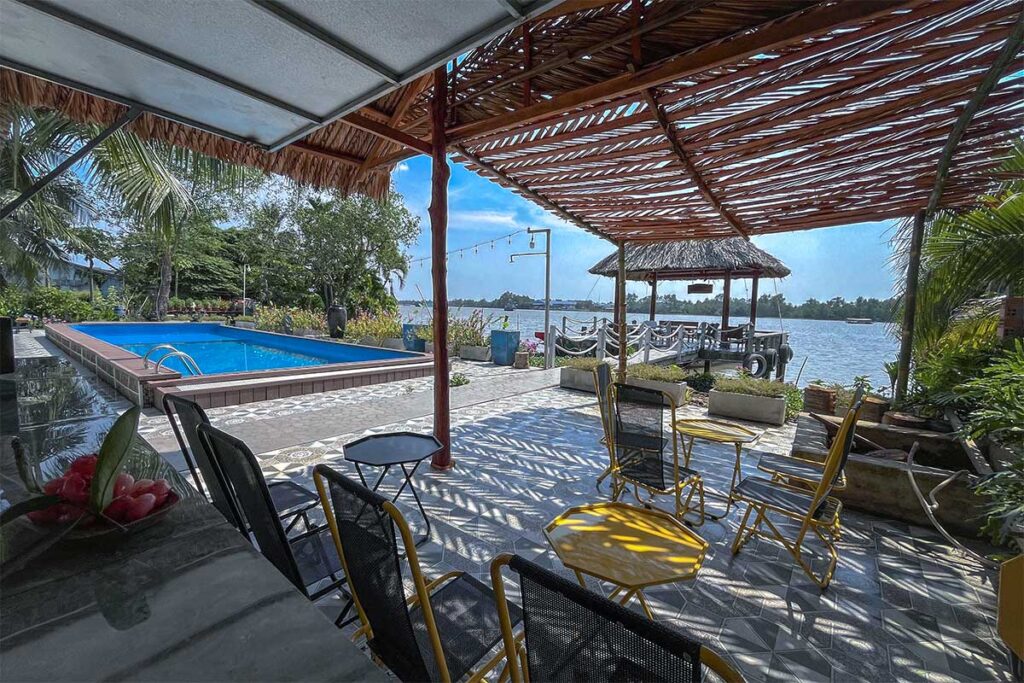 Riverside homestay on Phoenix Island with swimming pool, shaded terrace, and Mekong River views.