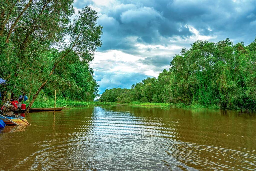 Wide river channel with boats at the entrance of Tram Chim National Park, Dong Thap