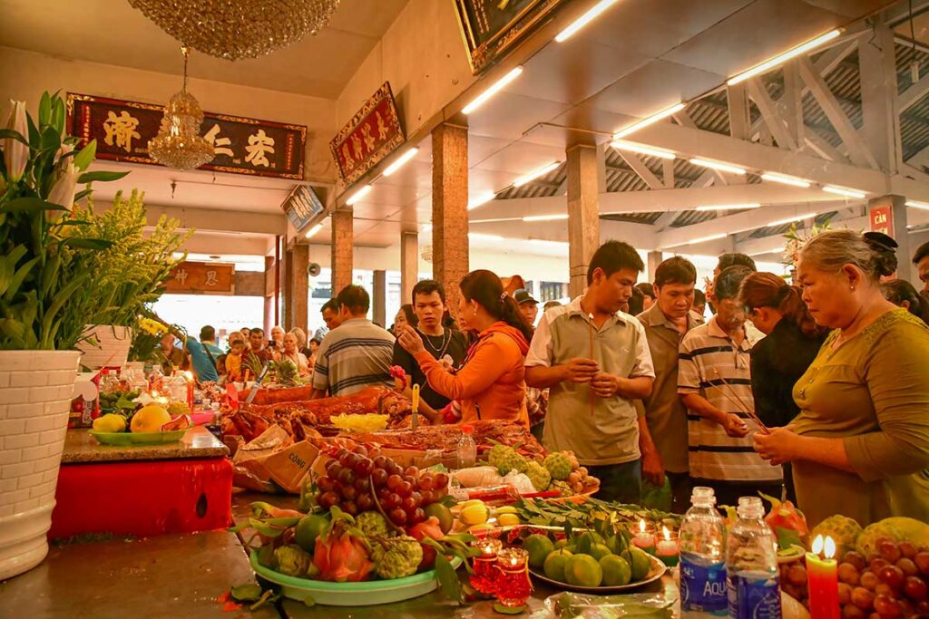 Pilgrims presenting fruit, flowers, and roast pig offerings at Ba Chua Xu Temple Festival