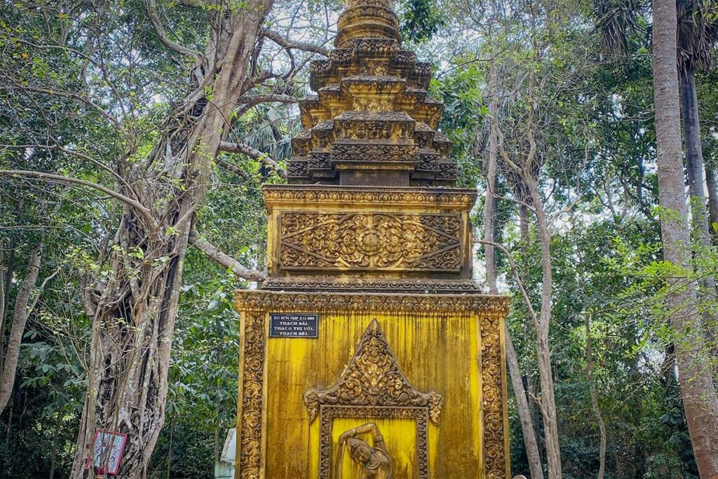 Golden stupa at Bat Pagoda (Chùa Dơi) in Soc Trang standing among ancient trees, used to hold ashes of abbots.