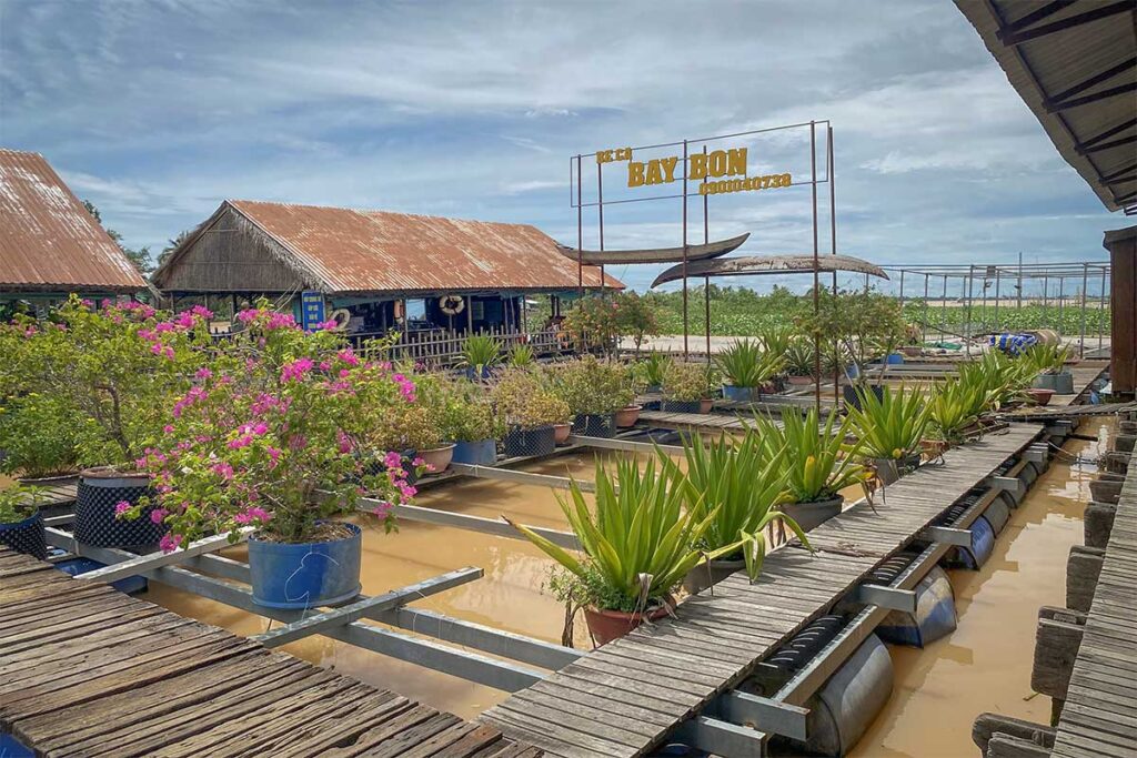Mr. Bay Bon’s fish raft with signboard and potted plants on Con Son Islet, Can Tho