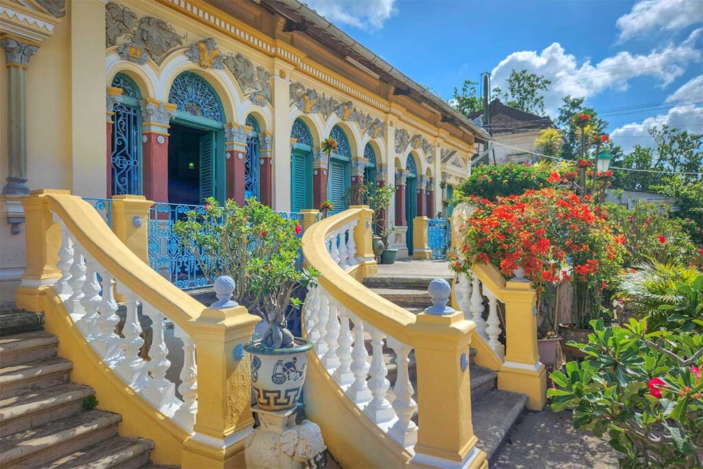 Close view of the curved staircases and colorful flower pots leading to Binh Thuy Ancient House in Can Tho.