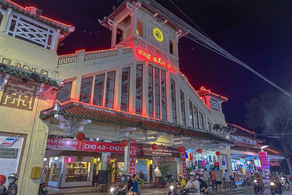 of Can Tho Market lit up at night with neon red lights