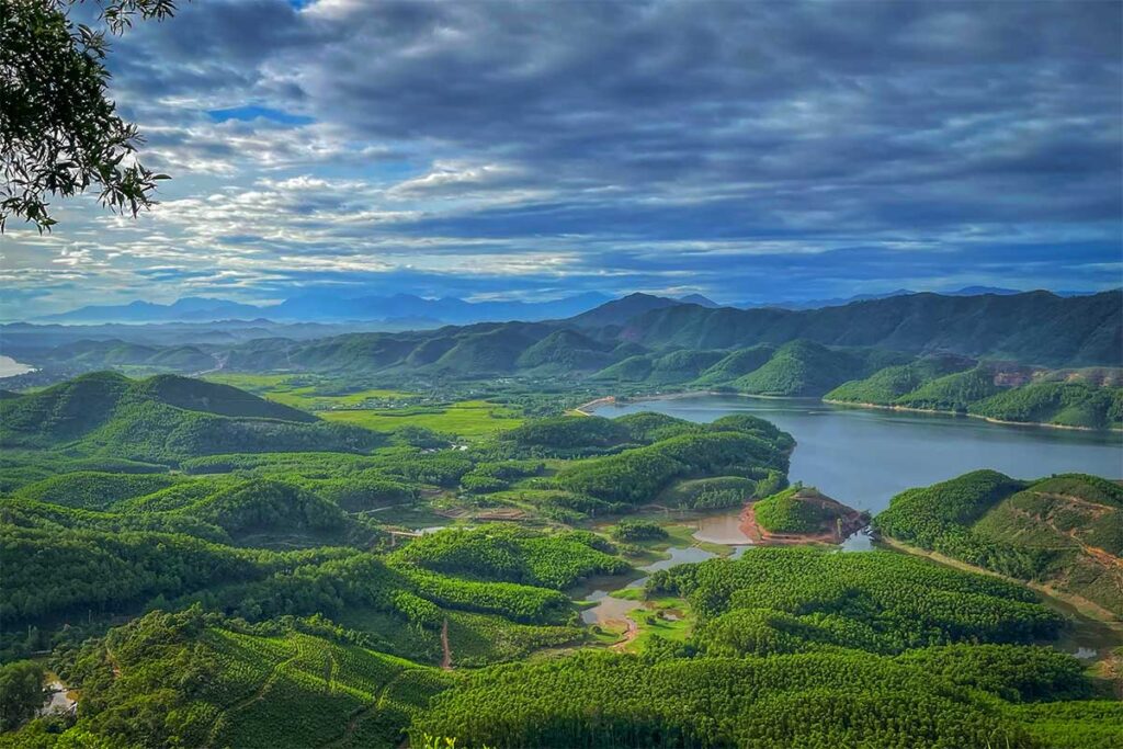 Panoramic view from Hon Vuon Peak showing Khe Ngang Lake and rolling green hills, one of the best natural viewpoints near Hue.