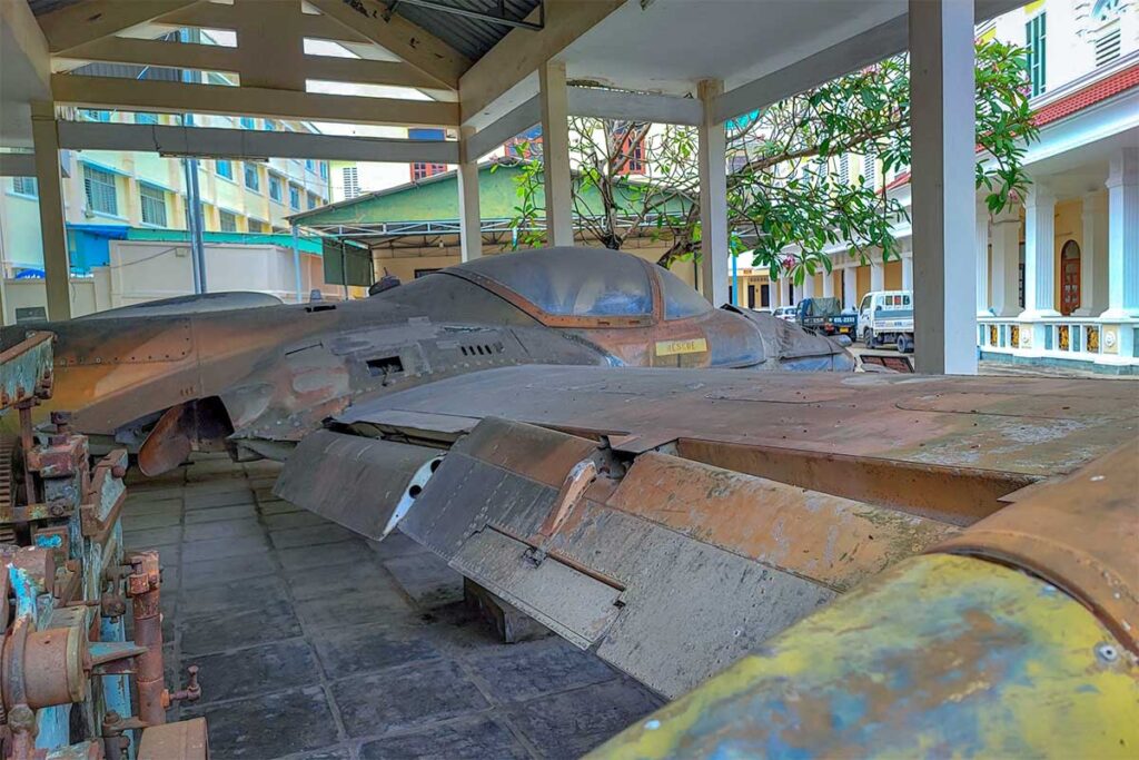 Rusting remains of a fighter plane displayed in the outdoor area of Military Zone 9 Museum in Can Tho
