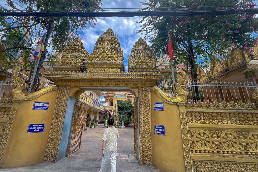 Golden entrance gate of Muniransay Khmer Buddhist Temple in Can Tho with three Angkor-style towers