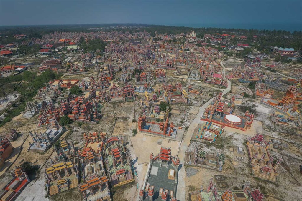 Aerial panorama of An Bang Cemetery in Hue, Vietnam — thousands of colorful tombs stretching across white sand toward the sea, forming the famous “City of Ghosts.”