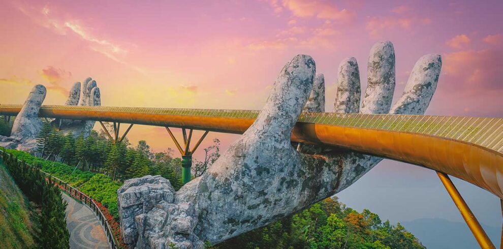 Golden Bridge Da Nang – Local Vietnam tours | aerial view of Ba Na Hills bridge held by giant stone hands at sunset