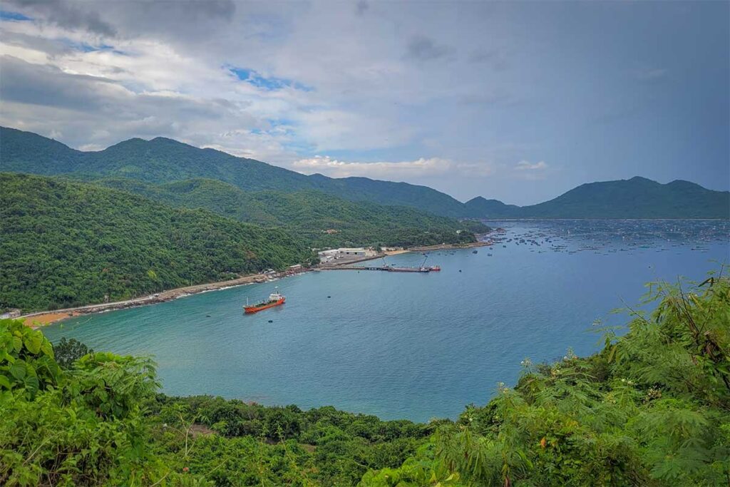 Vung Ro Bay seen from Deo Ca Pass – Panoramic view over Vung Ro Bay with fishing boats and deep blue waters, taken from the winding road of Deo Ca Pass.
