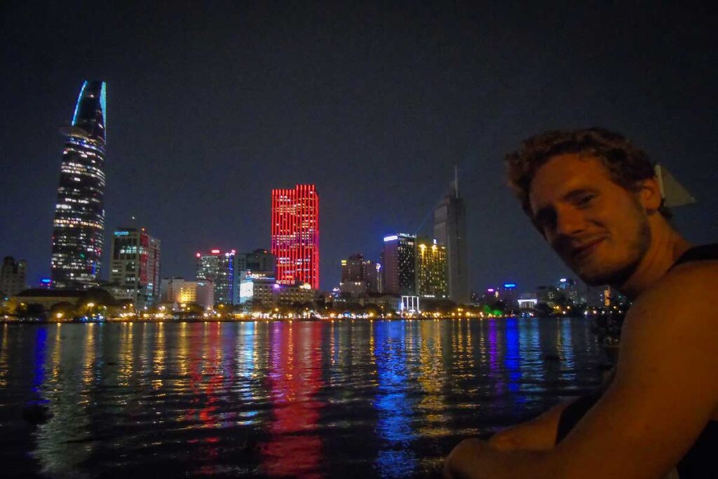 Marnick Schoonderwoerd from Local Vietnam overlooking the Saigon skyline at night while exploring Ho Chi Minh City to develop authentic local tours.