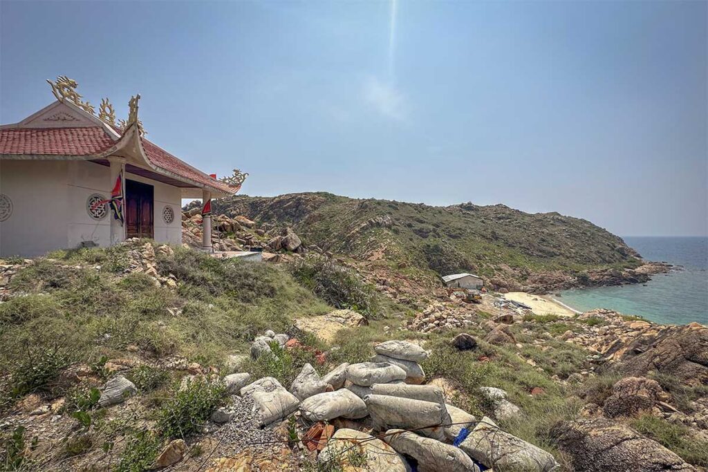 Hilltop temple at Nhon Hai – A small coastal temple with a red roof set among rocky hills, overlooking hidden beaches and the open sea.