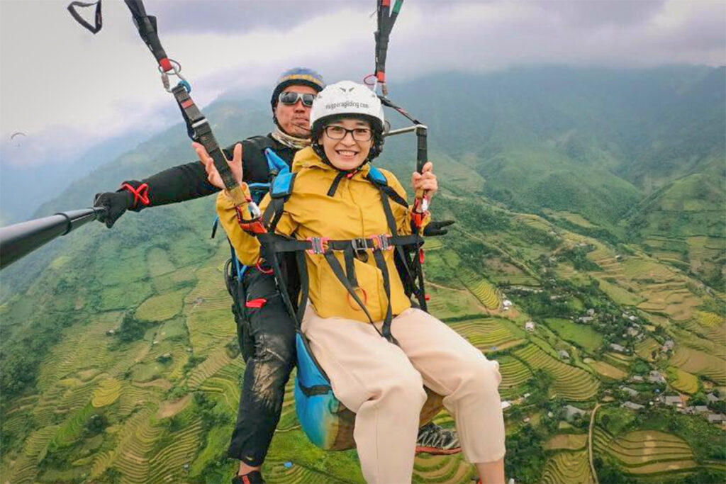 Linh Bui, manager at Local Vietnam, paragliding above the golden rice terraces of Mu Cang Chai in northern Vietnam — experiencing this iconic landscape firsthand as part of exploring new adventure and cultural tours for Local Vietnam.