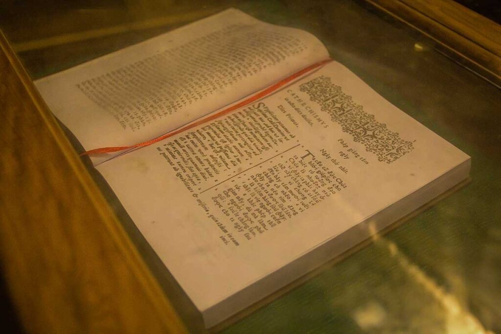 Close-up of Alexandre de Rhodes’ 1651 book “Phép Giảng Tám Ngày,” preserved in a glass case at Mang Lang Church, Phu Yen.