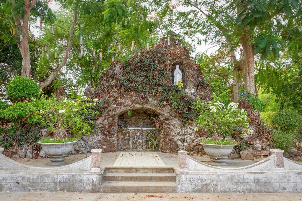Stone grotto at Mang Lang Church in Phu Yen, decorated with plants and a statue of the Virgin Mary above the altar space.