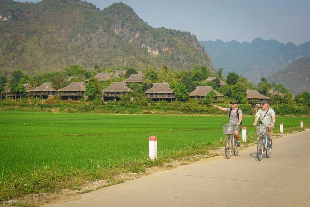Marnick Schoonderwoerd from Local Vietnam cycling with his father through rice fields in Mai Chau, Vietnam