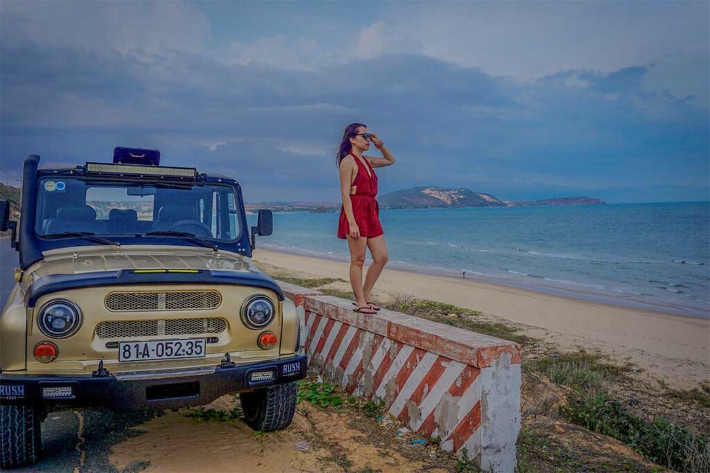 Nhung Phung from Local Vietnam standing beside a jeep on the coastal road of Mui Ne, Vietnam