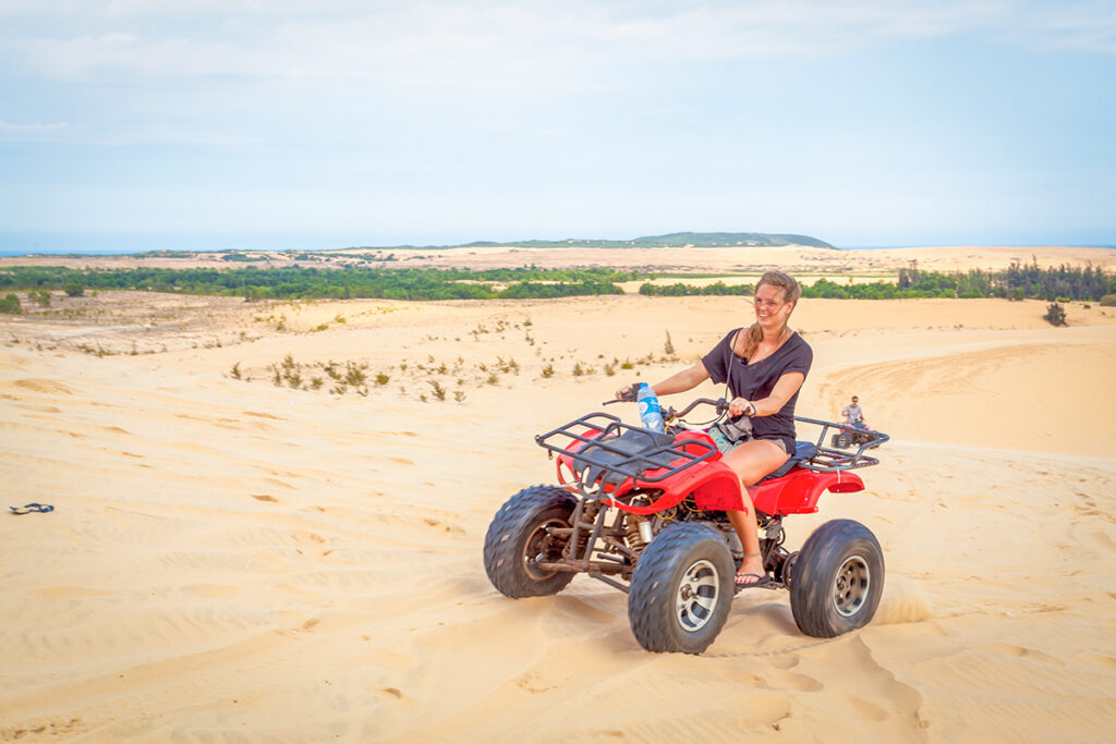 Mui Ne sand dunes – Local Vietnam tours | traveler riding a quad bike across the golden dunes in coastal Vietnam