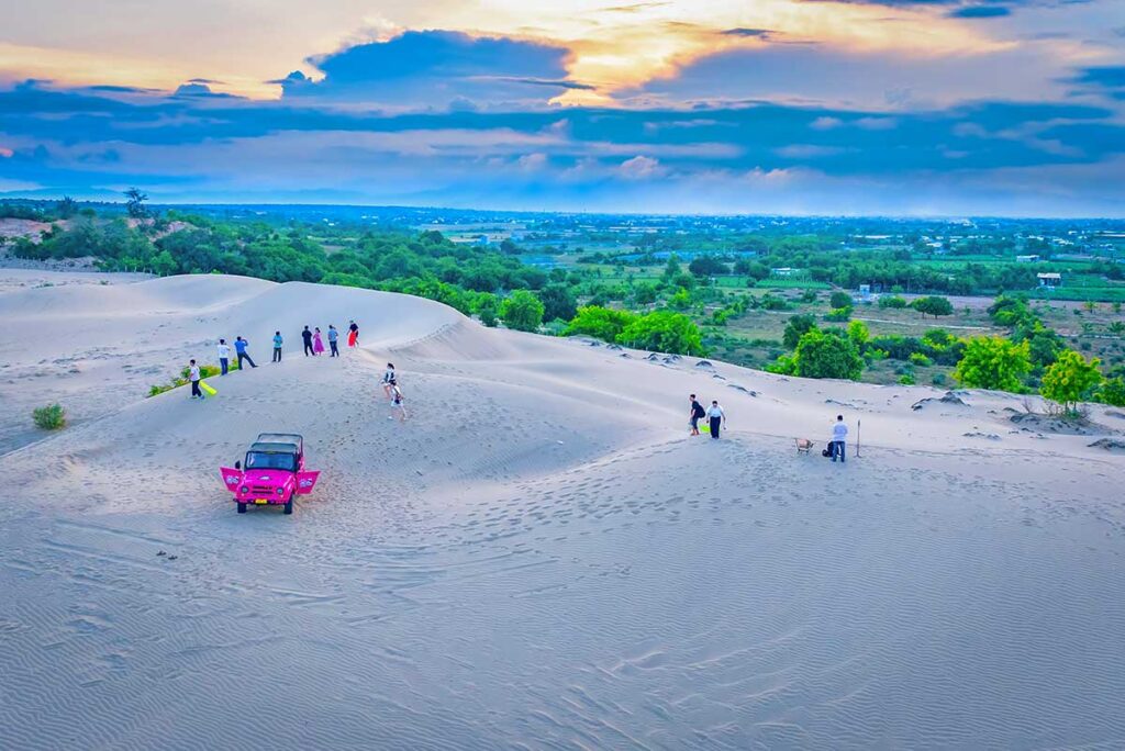 Group of visitors exploring Nam Cuong Sand Dunes by jeep near Phan Rang, Vietnam