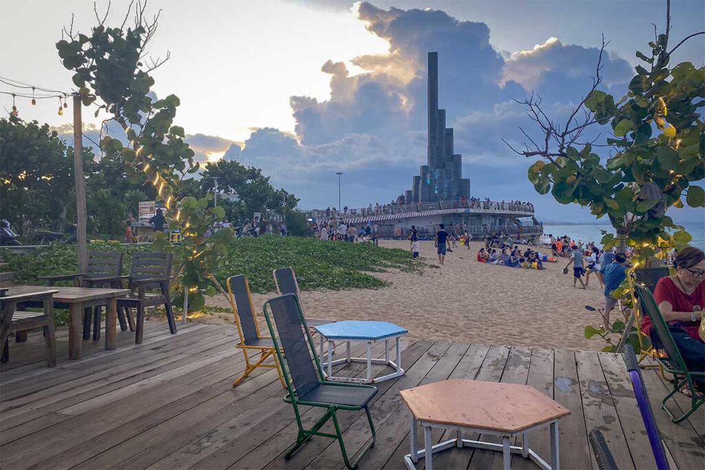 Beach café with ocean view and crowds gathering near Nghinh Phong Tower in Tuy Hoa at sunset.