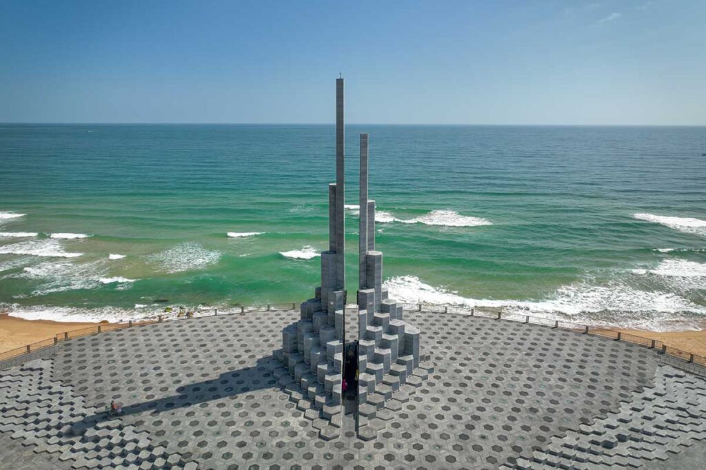 Aerial view of Nghinh Phong Tower in Tuy Hoa with turquoise waves of the East Sea in the background.