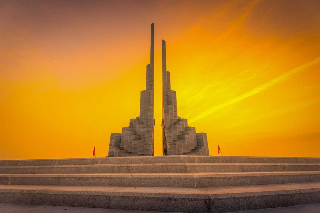 Nghinh Phong Tower at dusk with a dramatic orange sky along the Tuy Hoa beachfront.