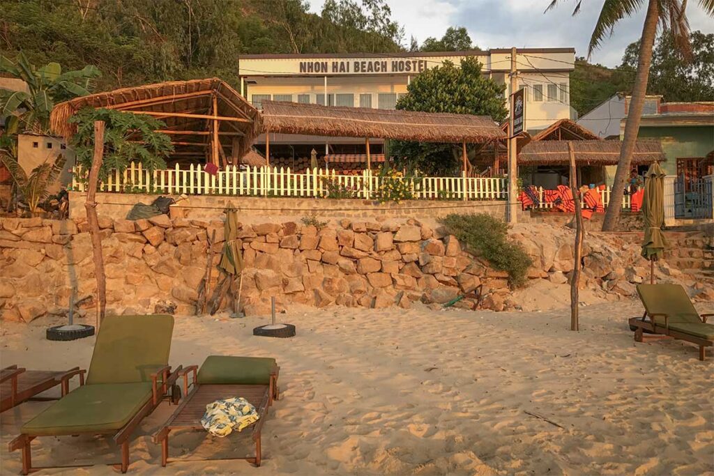 Nhon Hai Beach Hostel at sunset – A simple beachfront stay with bamboo huts and deck chairs right on the sand, offering a laid-back base in Nhon Hai Fishing Village.
