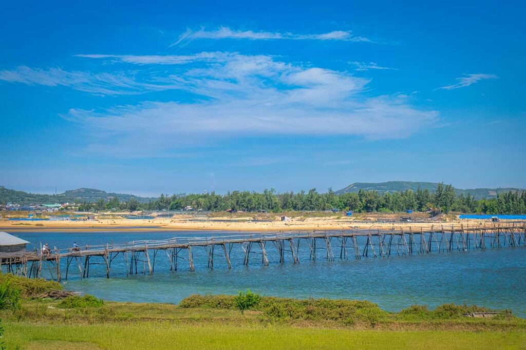 Panoramic view of Ong Cop Wooden Bridge across the blue waters of Phu Yen’s Binh Ba River, connecting Tuy An with Song Cau.