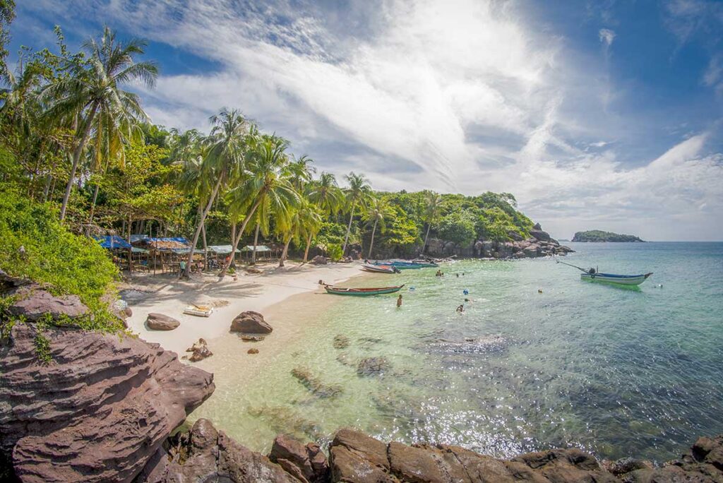 Phu Quoc Vietnam – Local Vietnam tours | small tropical beach with clear water and fishing boats on Phu Quoc Island