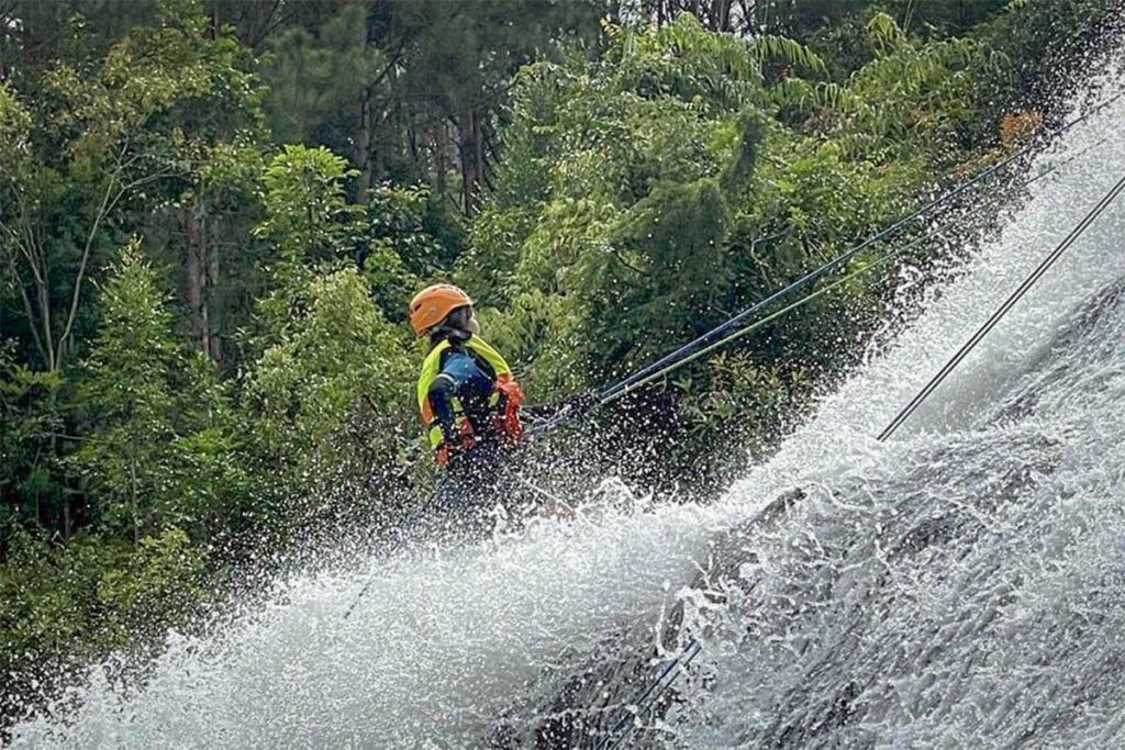 Tra Bui, member of the Local Vietnam expert team, abseiling down a waterfall during a canyoning adventure in Da Lat — exploring the city’s outdoor experiences firsthand to ensure authentic and safe adventure tours.