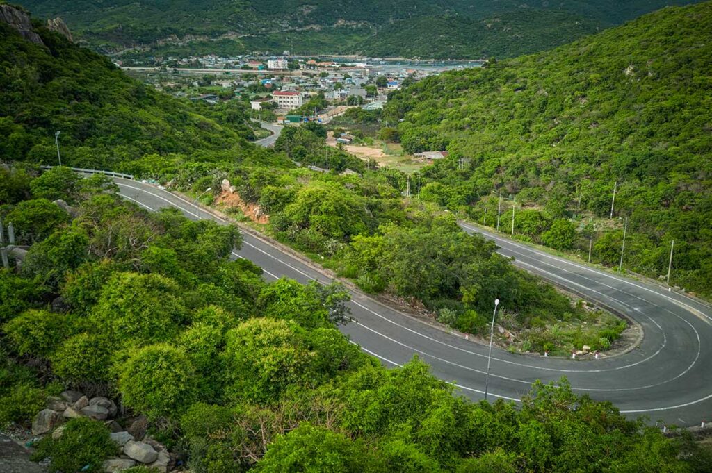 Winding coastal road near Vinh Hy Bay – The curving DT702 mountain road cutting through lush greenery, offering one of Vietnam’s most scenic drives toward Vinh Hy Bay.