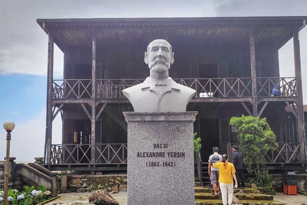 Statue of Alexandre Yersin in front of his historic wooden house at Hon Ba summit, a cultural highlight of the Hon Ba Nature Reserve near Nha Trang.