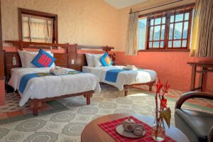 Double bed in the Connecting Family Room at Ha Giang Aya Lodge with large windows overlooking the mountains.