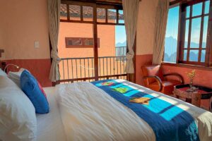 Deluxe Room at Ha Giang Aya Lodge featuring a double bed, balcony doors and bright natural light.