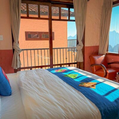 Deluxe Room at Ha Giang Aya Lodge featuring a double bed, balcony doors and bright natural light.