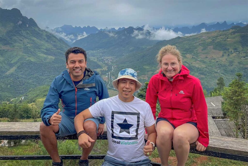 Local Vietnam guide with travelers overlooking the Ha Giang mountains, showcasing the agency’s personalized tours and deep local expertise.