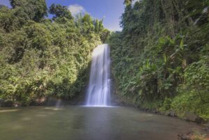 Mang Den tours featuring Psy Waterfall surrounded by dense tropical forest