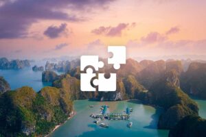 Private Halong Bay tour with a custom itinerary, cruising among limestone islands and peaceful emerald waters at sunset.