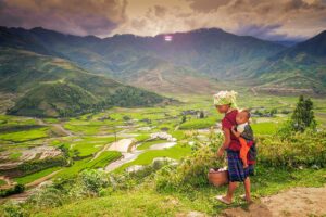 Hmong woman carrying her baby overlooking rice terraces in Sapa — a classic stop on cultural Vietnam tours and scenic Vietnam itineraries in the north.