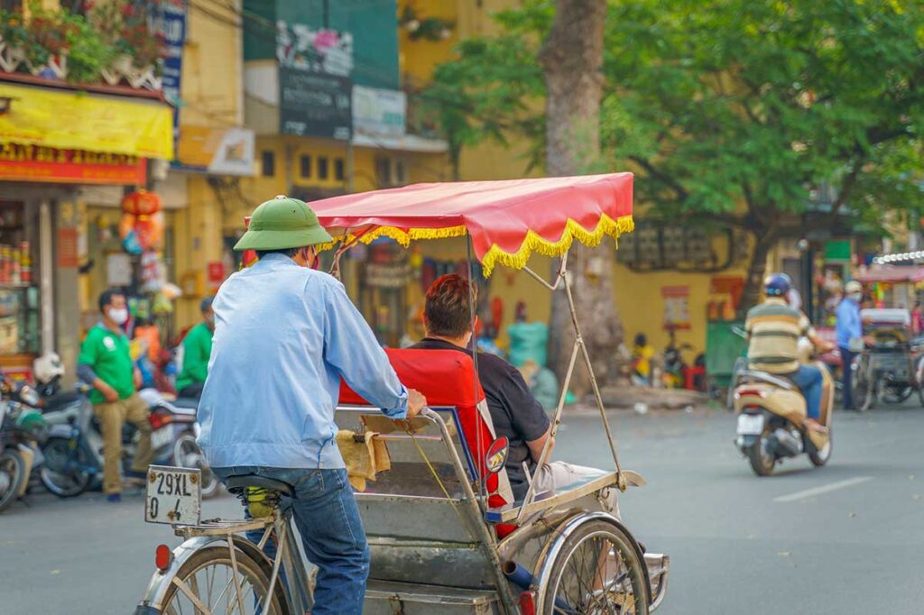 Cyclo ride through the busy streets of Hanoi’s Old Quarter, a classic way to explore the capital during Vietnam tours.