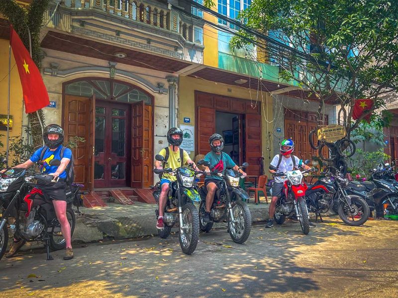 A group of foreign tourists sitting on their rented big motorbikes at a motorbike rental in Cao Bang