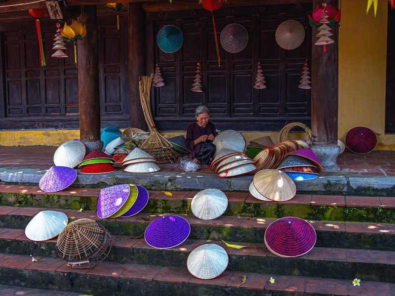 woman crafting traditional conical hats at Chuong Conical Hat Village near Hanoi