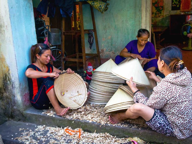 woman crafting traditional conical hats at Chuong Conical Hat Village near Hanoi