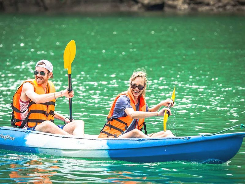 A group of friends kayaking through Lan Ha Bay