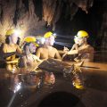 A group of travelers are in a bath full of mud inside the Dark Cave
